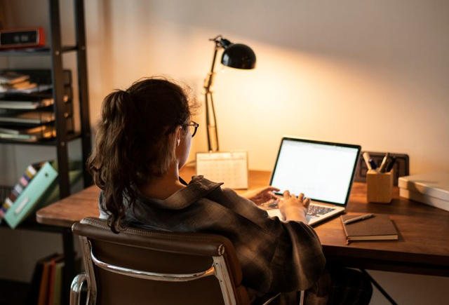 Girl works on her homeschool work while sitting at a desk. 