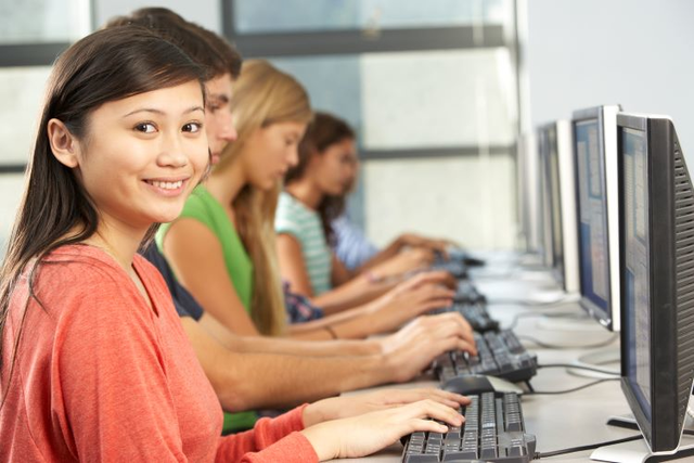 A student takes notes on a computer in a computer lab, a great study tip for visual learners.